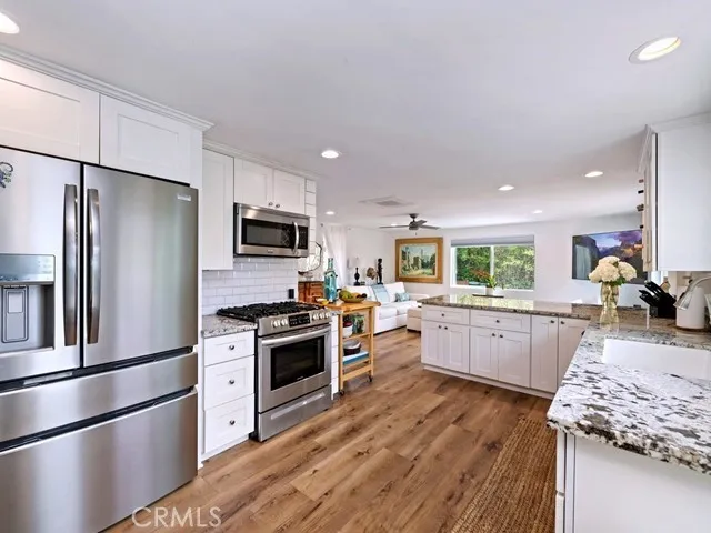 a kitchen with granite countertop stainless steel appliances and wooden cabinets