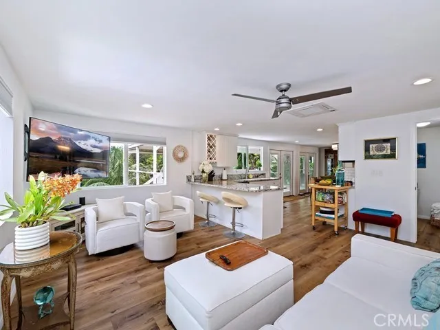 a living room with furniture kitchen view and a large window
