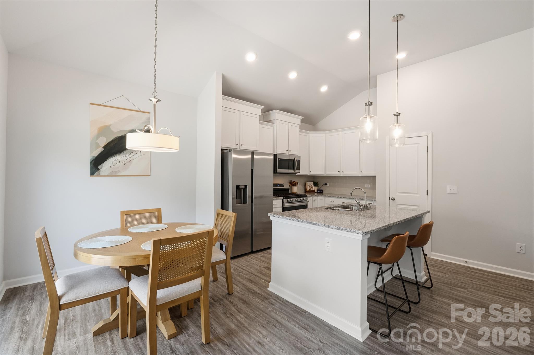 8220 Mccormick Street Terrell, NC 28682 - Photo 11 of 33 a kitchen with stainless steel appliances kitchen island granite countertop a table chairs and a refrigerator