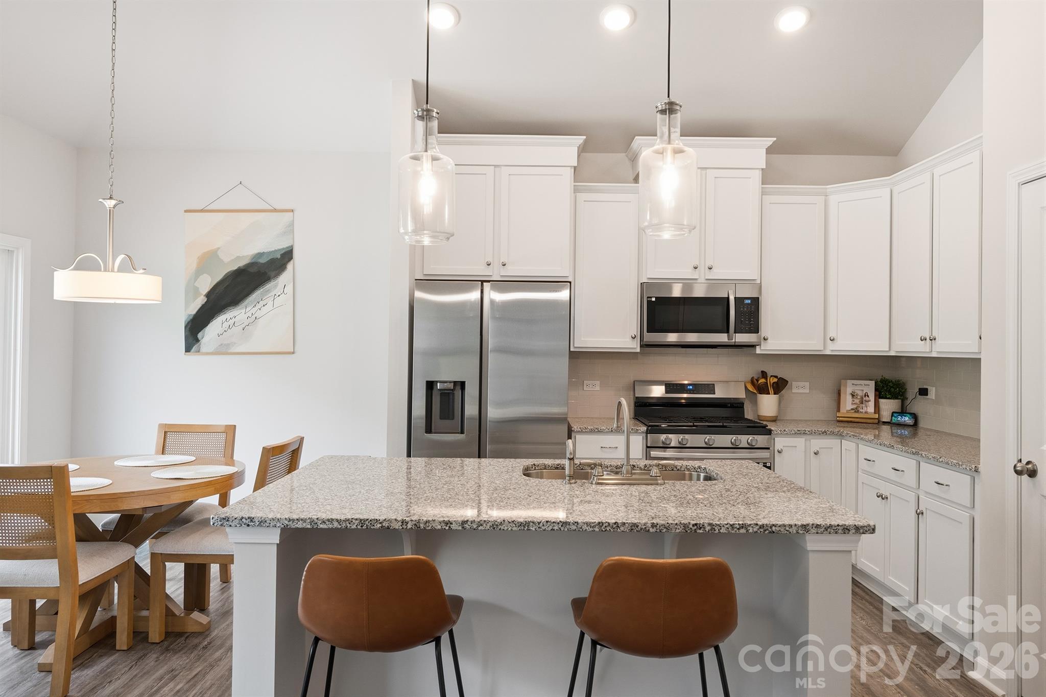 8220 Mccormick Street Terrell, NC 28682 - Photo 13 of 33 a kitchen with stainless steel appliances granite countertop a table chairs stove and refrigerator