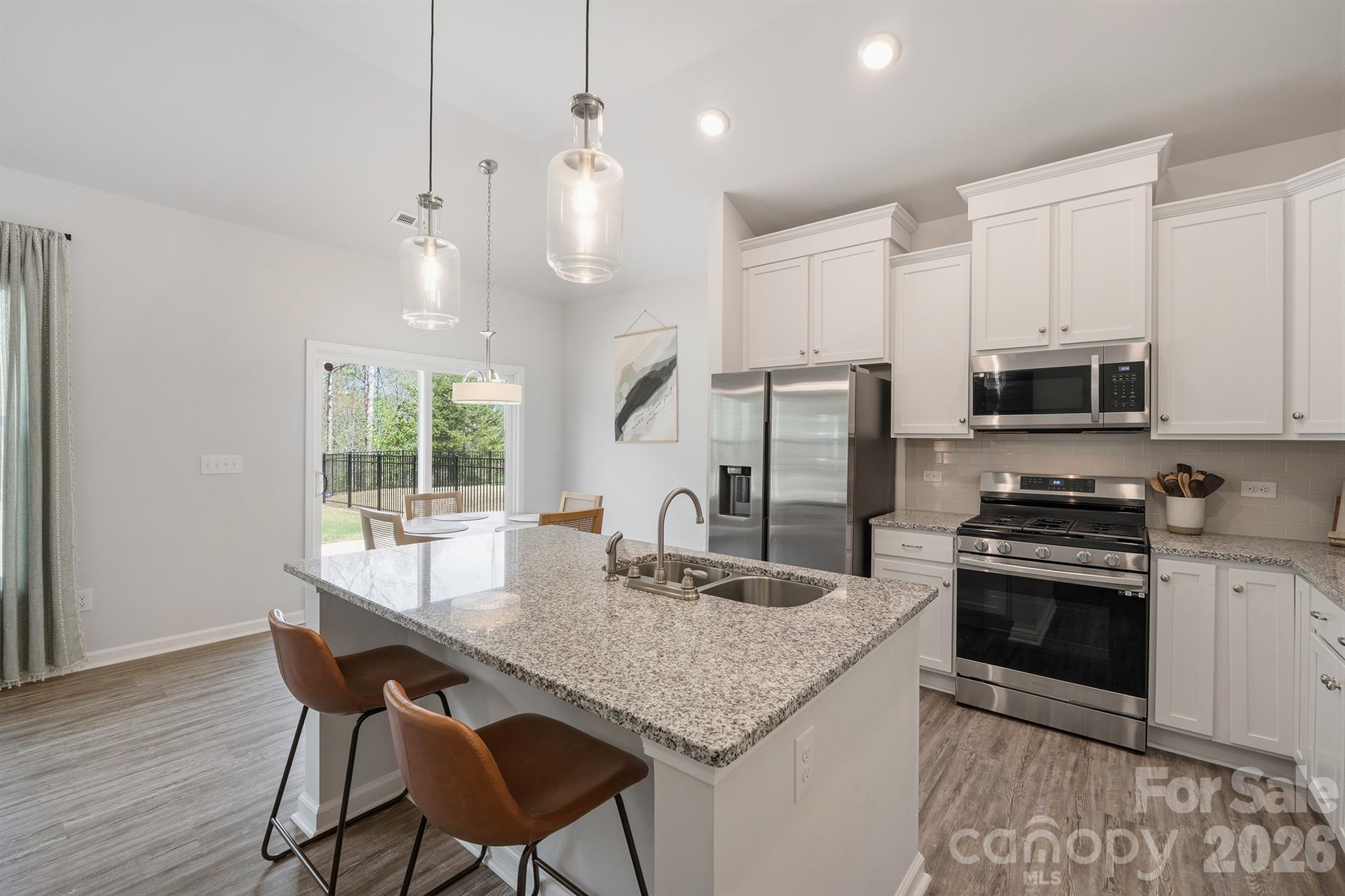 8220 Mccormick Street Terrell, NC 28682 - Photo 7 of 33 a kitchen with stainless steel appliances granite countertop a stove a refrigerator a kitchen island a sink cabinets and wooden floor