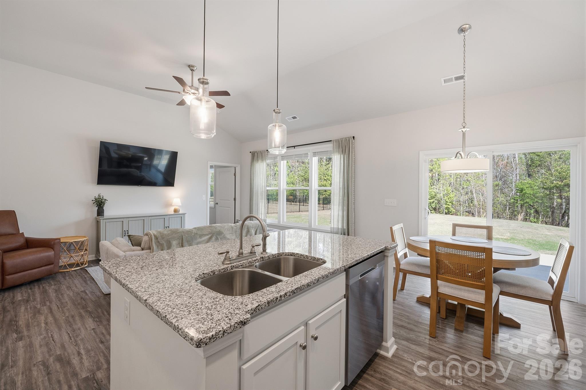 8220 Mccormick Street Terrell, NC 28682 - Photo 10 of 33 a kitchen with a center island a sink dishwasher a dining table and chairs with wooden floor