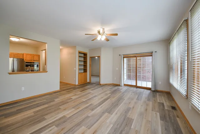 a view of an empty room with a window and wooden floor