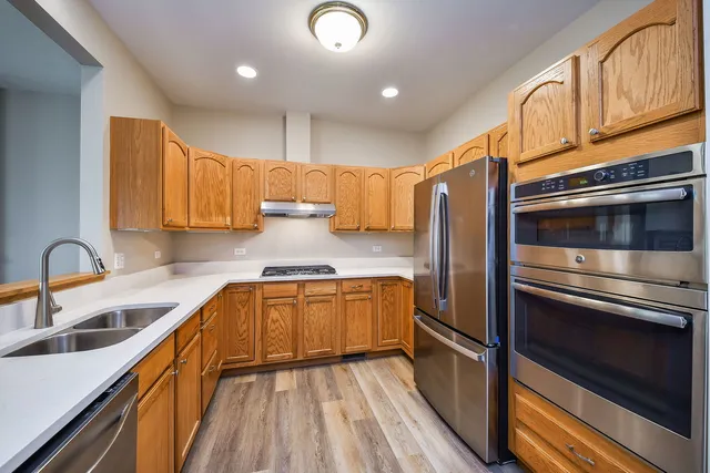 a kitchen with granite countertop stainless steel appliances and wooden cabinets