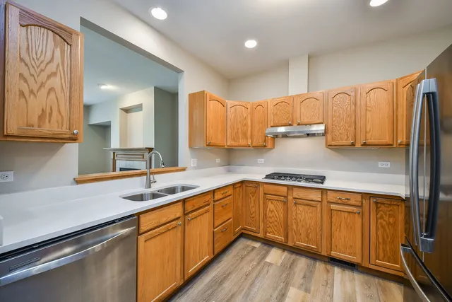 a kitchen with stainless steel appliances granite countertop a sink stove and cabinets