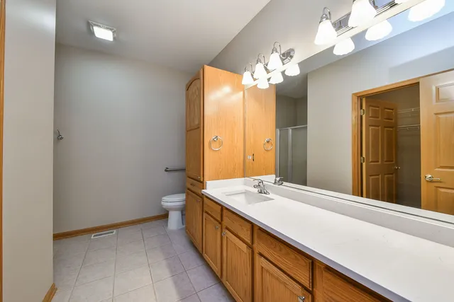a bathroom with a sink a large mirror and a toilet