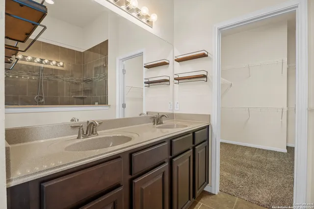a bathroom with a granite countertop sink a mirror and a shower