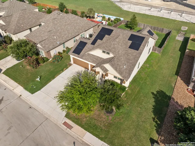 an aerial view of a house with a garden and lake view