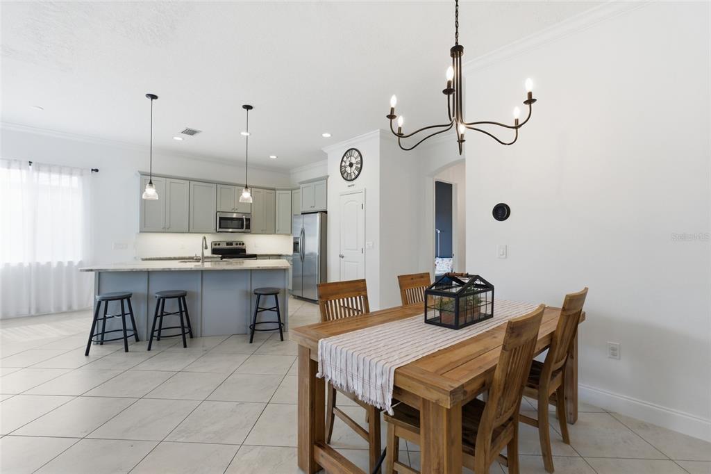 4437 Meridian Road Venice, FL 34293 - Photo 11 of 37 a kitchen with kitchen island a dining table and chairs