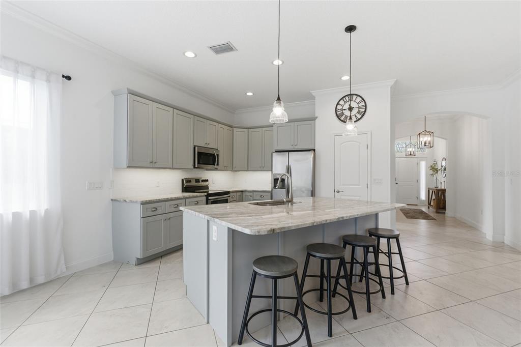4437 Meridian Road Venice, FL 34293 - Photo 12 of 37 a kitchen with stainless steel appliances granite countertop a sink a stove a refrigerator and island