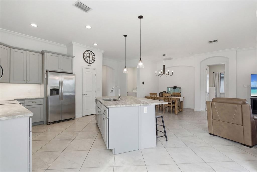 4437 Meridian Road Venice, FL 34293 - Photo 13 of 37 a kitchen with a sink a counter and chairs
