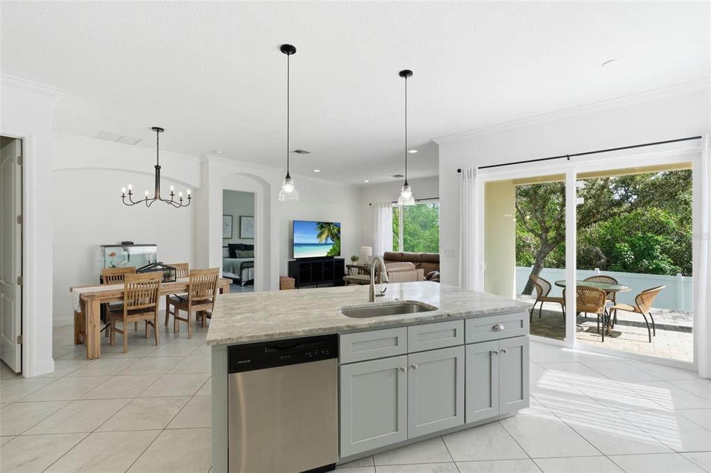4437 Meridian Road Venice, FL 34293 - Photo 16 of 37 a large kitchen with kitchen island granite countertop a large counter top space and stainless steel appliances