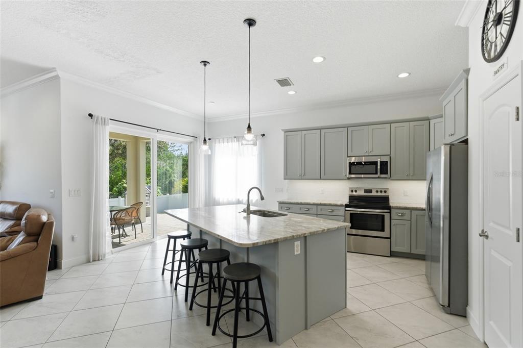 4437 Meridian Road Venice, FL 34293 - Photo 17 of 37 a kitchen with kitchen island granite countertop a stove a sink a oven a dining table and chairs
