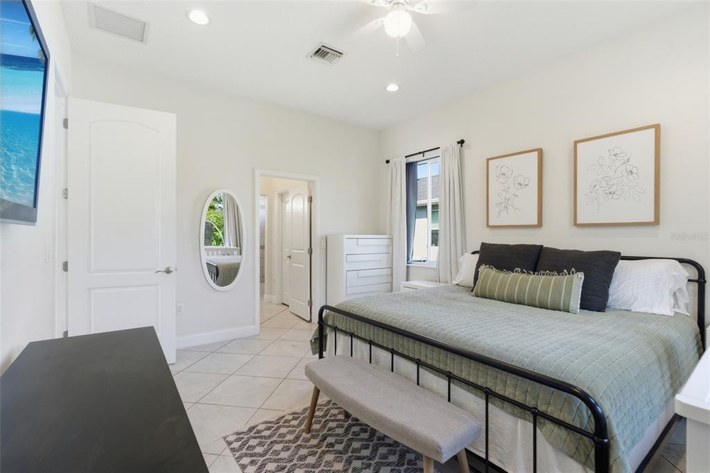 4437 Meridian Road Venice, FL 34293 - Photo 19 of 37 a large bedroom with a bed and painting on the wall