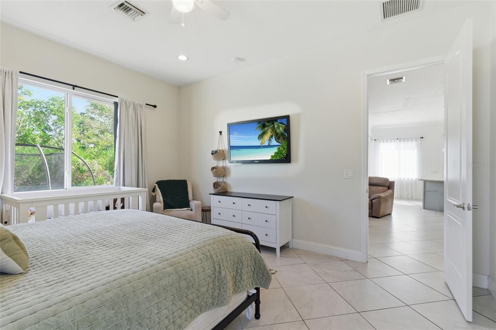 4437 Meridian Road Venice, FL 34293 - Photo 21 of 37 a spacious bedroom with a bed and a couch