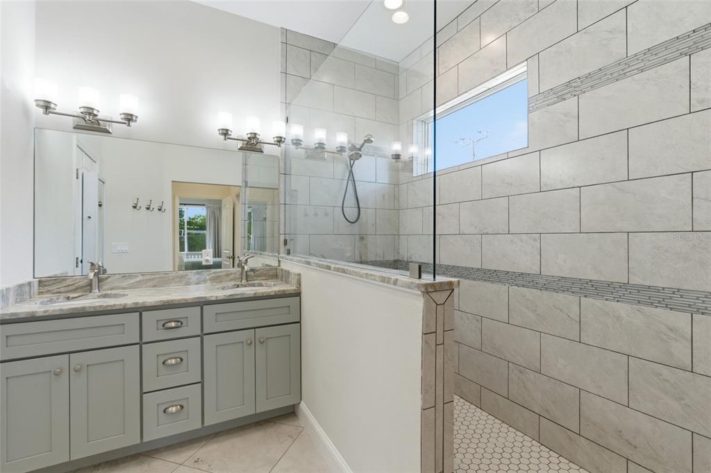 4437 Meridian Road Venice, FL 34293 - Photo 23 of 37 a bathroom with a granite countertop sink a mirror and shower
