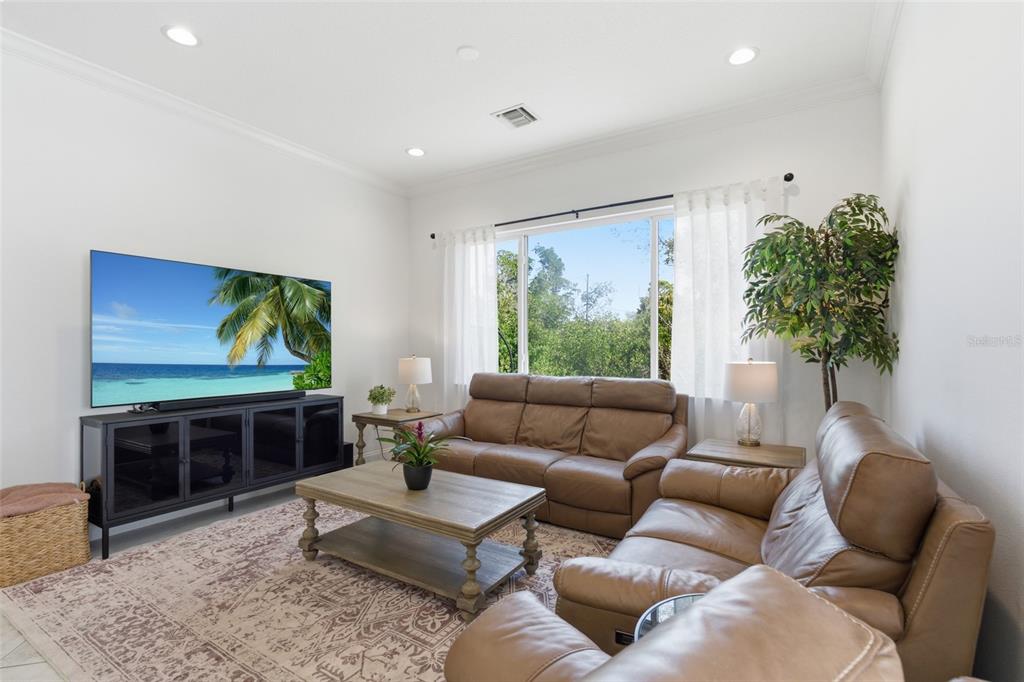 4437 Meridian Road Venice, FL 34293 - Photo 6 of 37 a living room with furniture and a flat screen tv