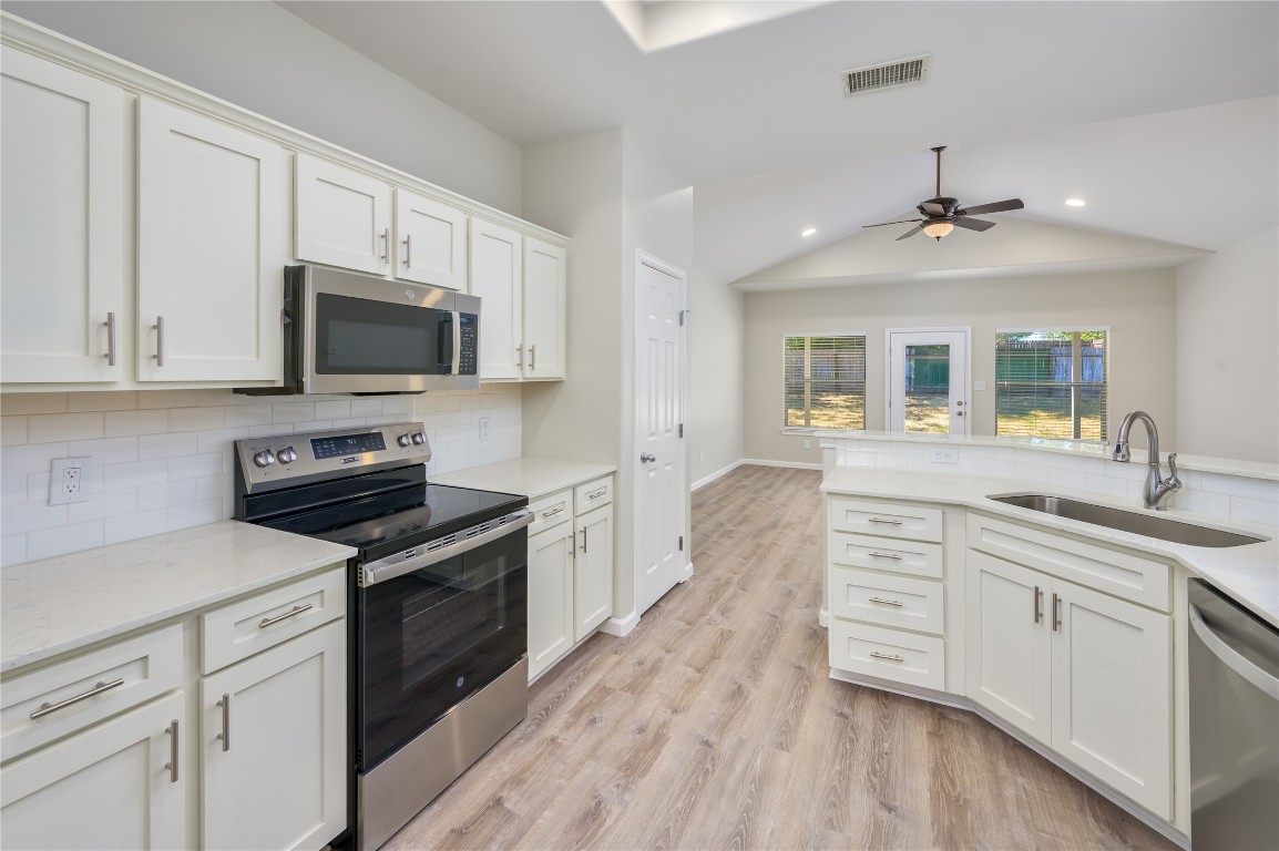 a kitchen with a sink stove and microwave