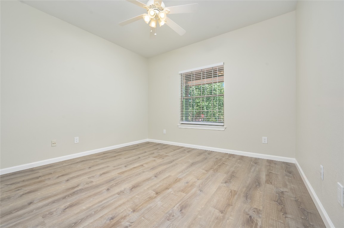 2016 Whitebead Trail Austin, TX 78734 - Photo 12 of 31 an empty room with wooden floor chandelier fan and windows