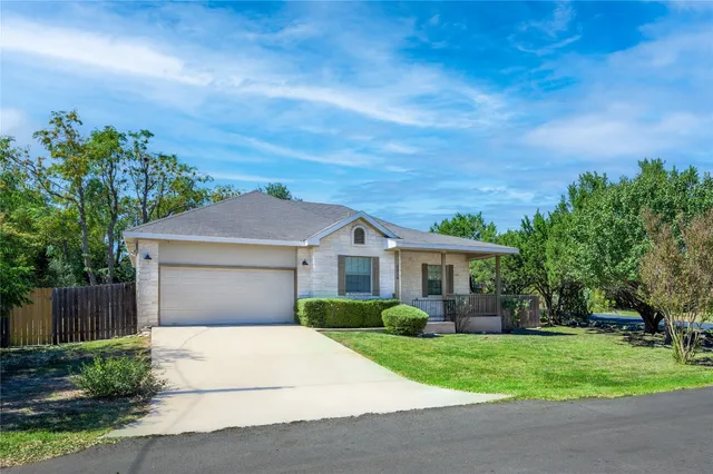 a front view of a house with a garden and plants