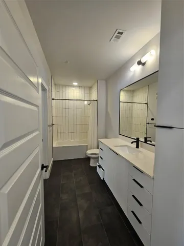 a bathroom with a double vanity sink toilet mirror and tub