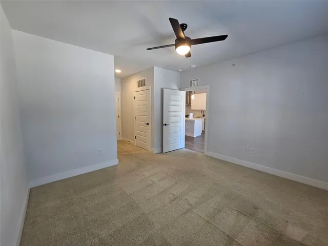 an empty room with closet and fan