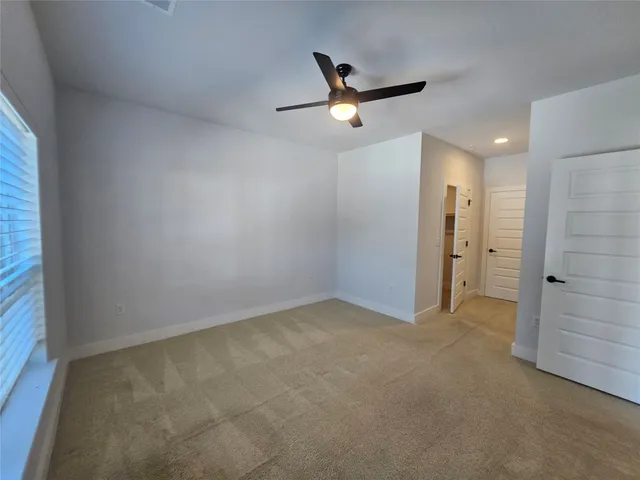 an empty room with closet and a chandelier fan