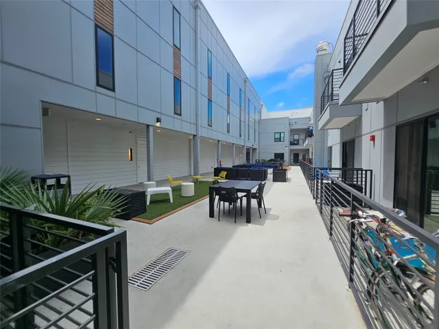 a living room with stainless steel appliances furniture a dining table and a flat screen tv