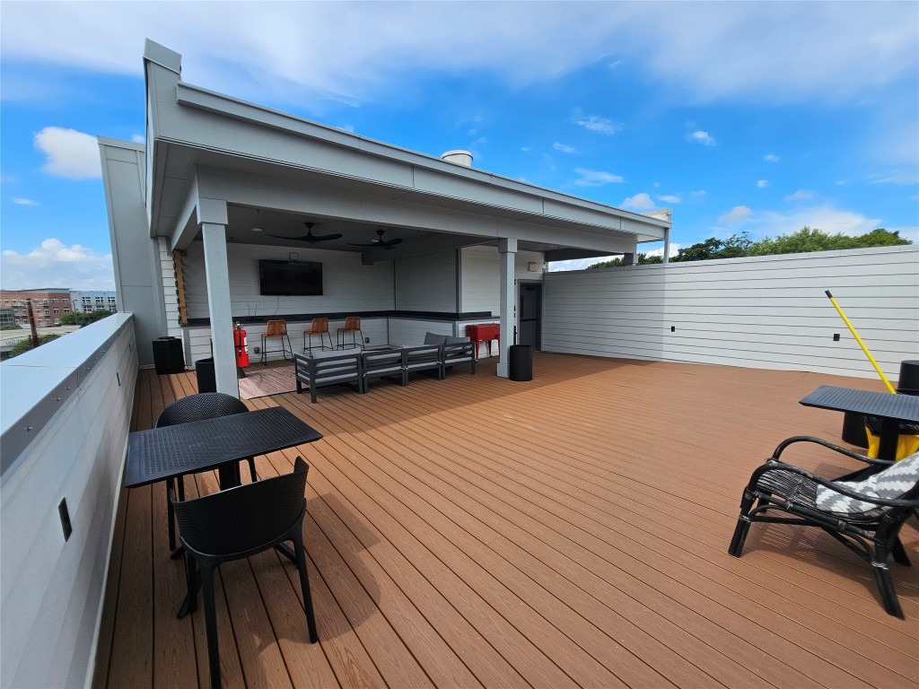 2220 Webberville Road, Unit 310 Austin, TX 78702 - Photo 39 of 39 a view of a roof deck with table and chairs a barbeque with wooden floor and fence