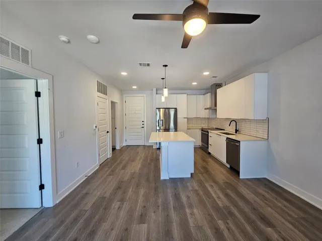 a kitchen with kitchen island white cabinets and stainless steel appliances