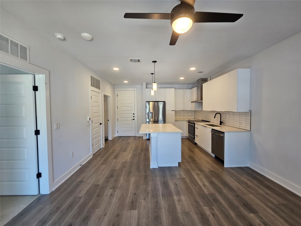 2220 Webberville Road, Unit 310 Austin, TX 78702 - Photo 8 of 39 a kitchen with kitchen island white cabinets and stainless steel appliances