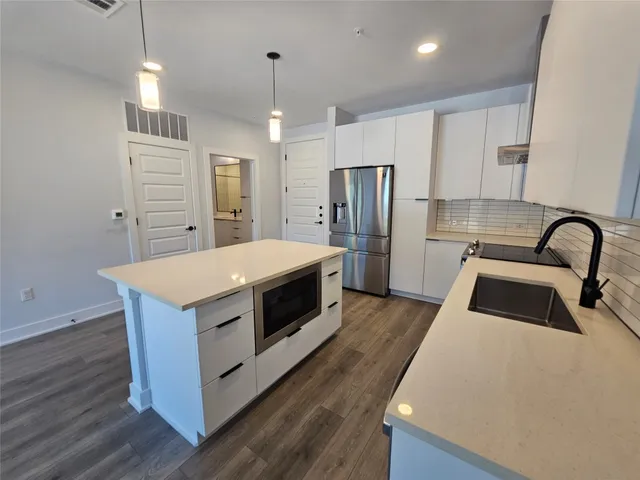 a kitchen with stainless steel appliances a stove a sink a refrigerator and cabinets