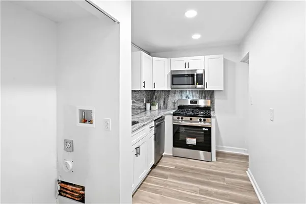 a kitchen with stainless steel appliances granite countertop a refrigerator and a stove