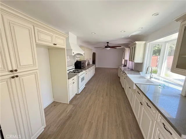 a kitchen with granite countertop a sink and wooden floor