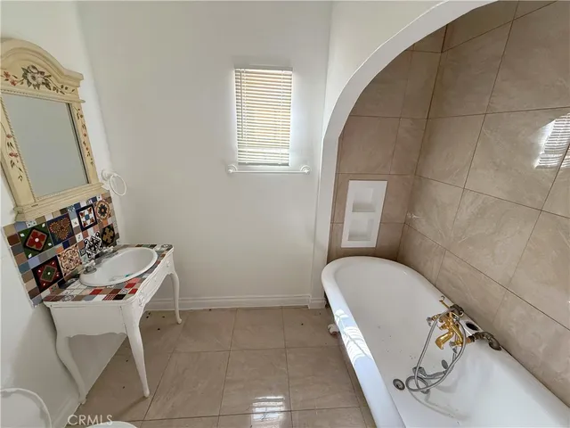 a bathroom with a tub sink and mirror