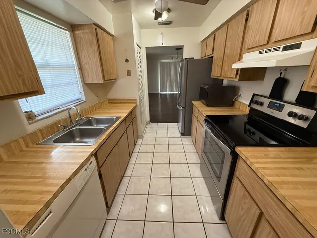 a kitchen with a sink a stove and a refrigerator