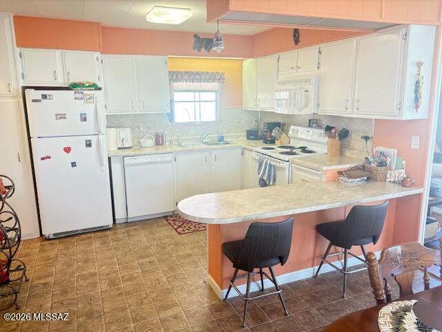 5731 West Flying M Street Tucson, AZ 85713 - Photo 12 of 20 a kitchen with stainless steel appliances granite countertop a white refrigerator a sink dishwasher and white cabinets next to a window