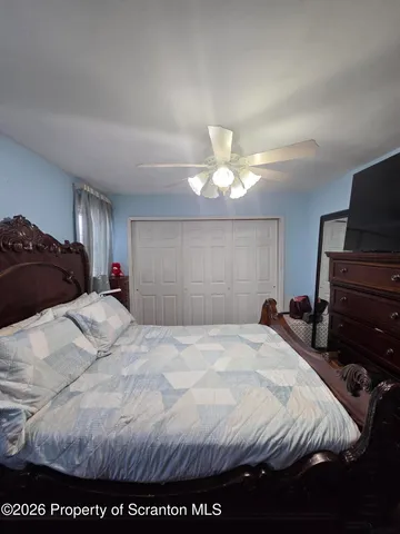 a large bedroom with a bed and a mirror on dresser
