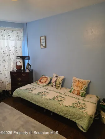 a bedroom with a bed and a lamp on dresser