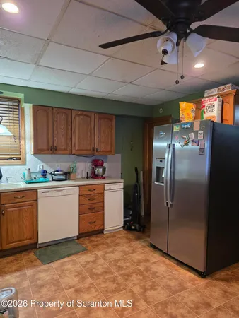 a kitchen with granite countertop a refrigerator and cabinets
