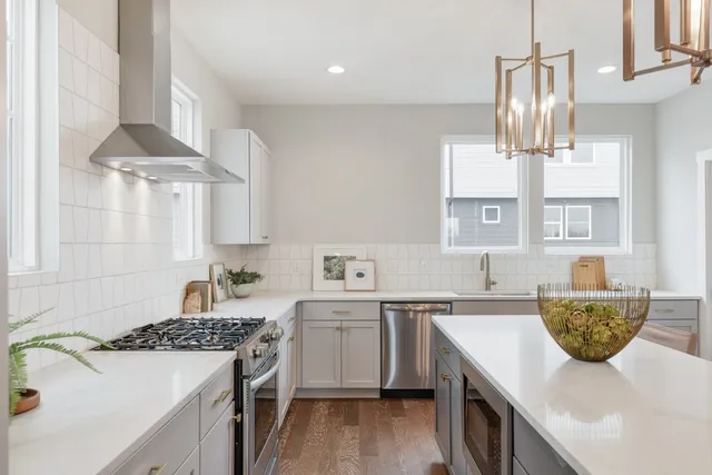 a kitchen with a sink dishwasher a stove a dining table and chairs