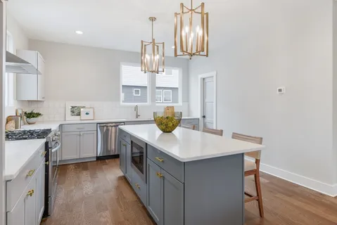 a kitchen with a sink a counter space appliances and cabinets