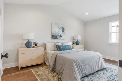 a bedroom with a bed and a painting on the wall