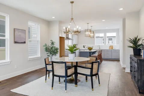 a dining room with furniture potted plants and wooden floor