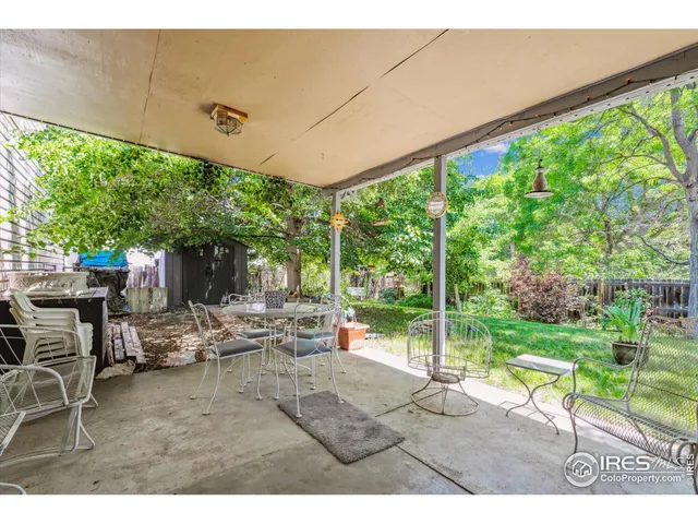 a view of a table and chairs in patio next to a yard
