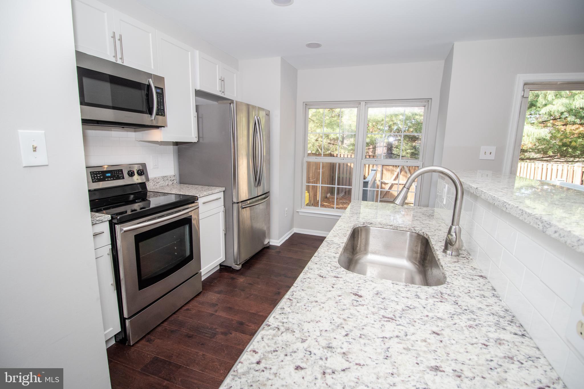 7708 Scatteree Road Severn, MD 21144 - Photo 15 of 41 a kitchen with a stove a sink and a microwave