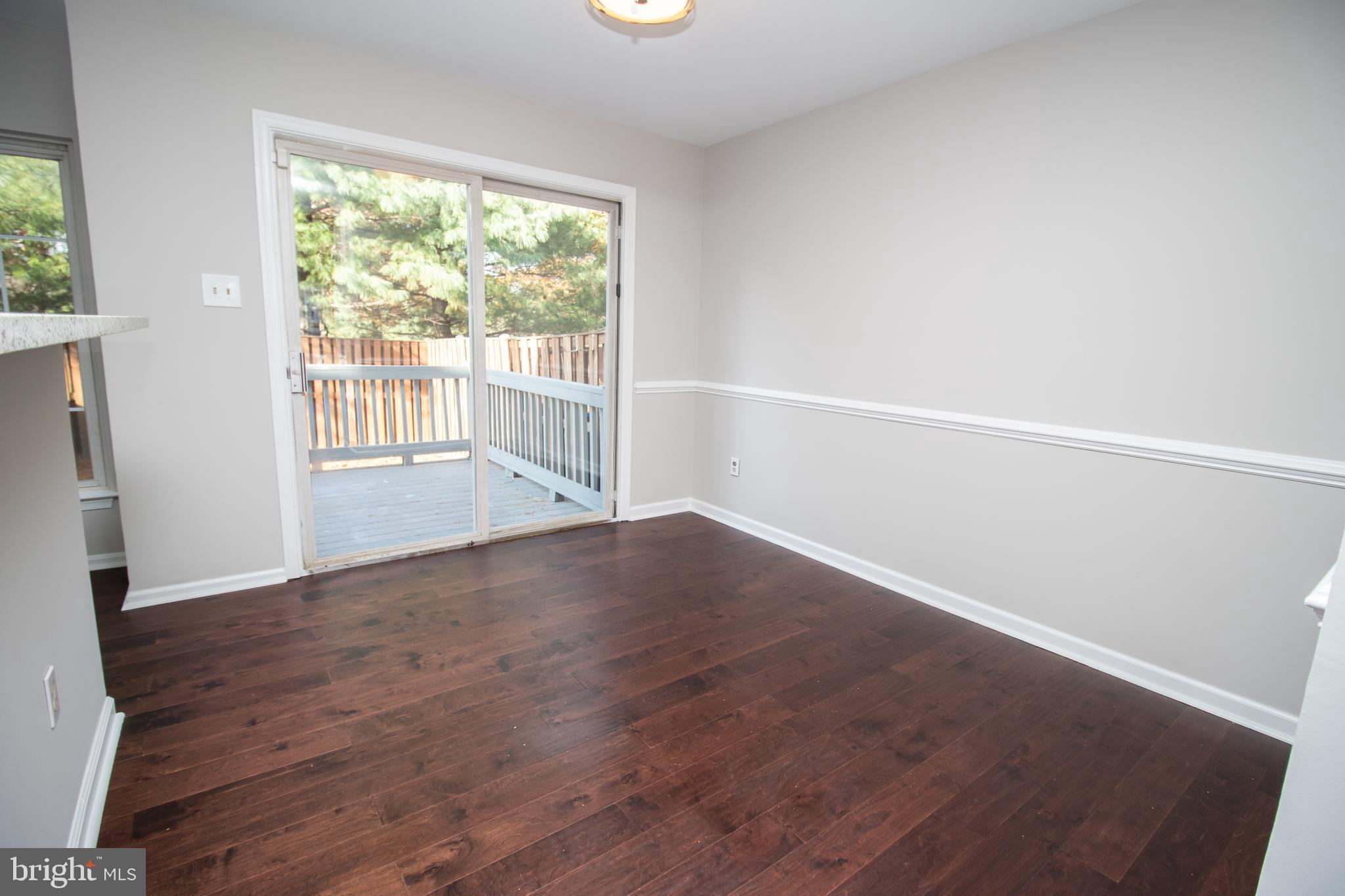7708 Scatteree Road Severn, MD 21144 - Photo 3 of 41 a view of an empty room with wooden floor and a window