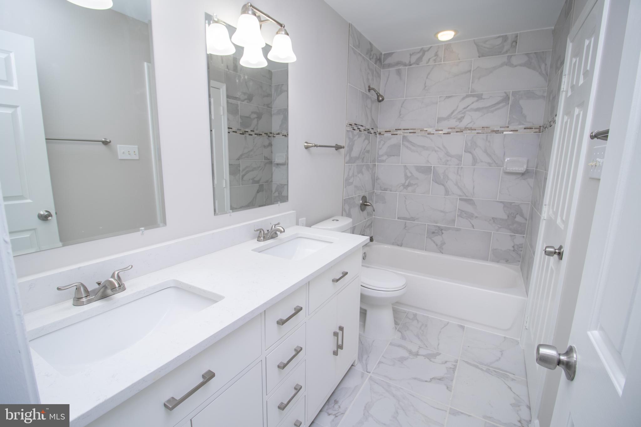 7708 Scatteree Road Severn, MD 21144 - Photo 29 of 41 a bathroom with a sink double vanity granite tub shower and a mirror