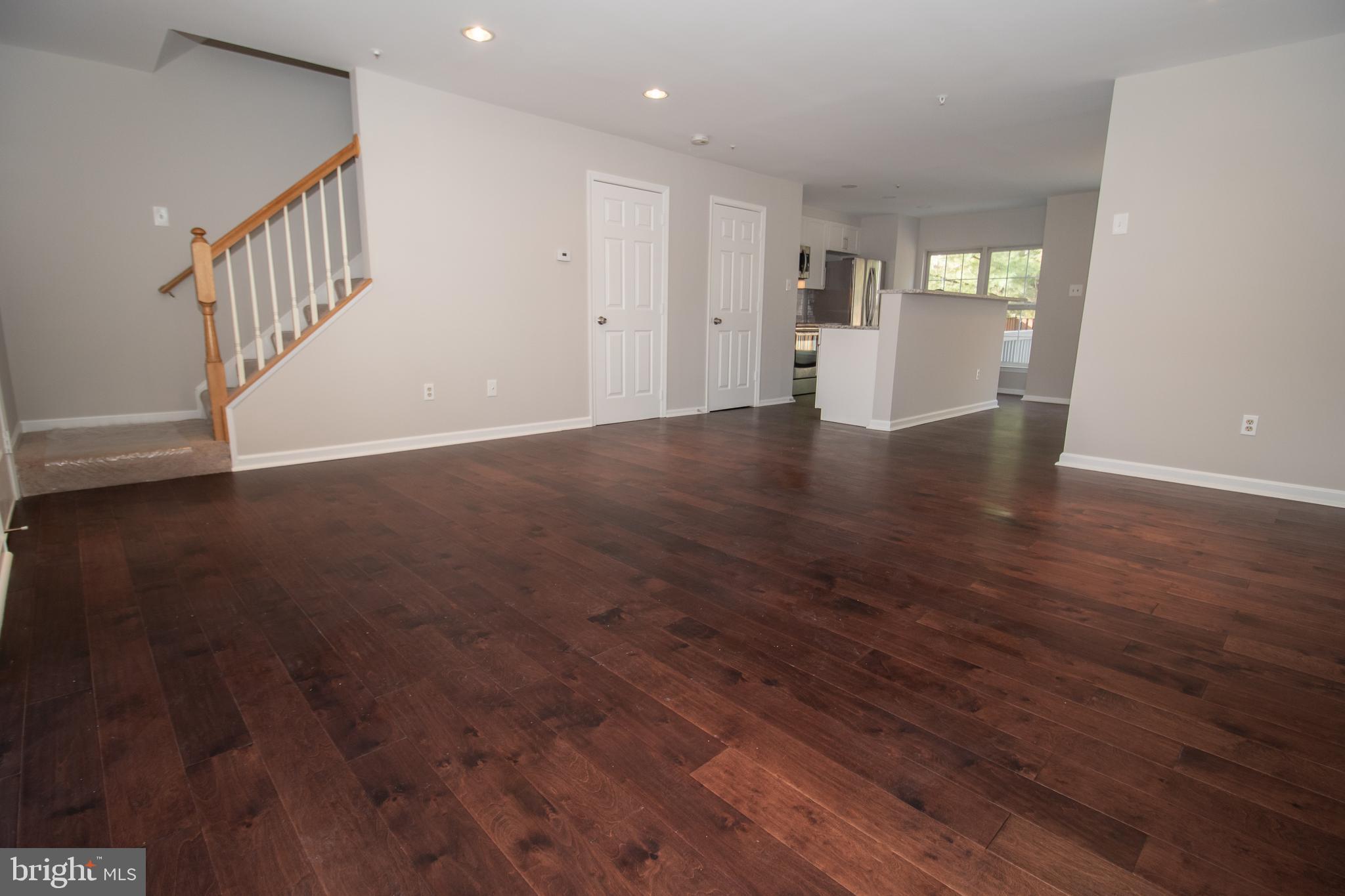 7708 Scatteree Road Severn, MD 21144 - Photo 4 of 41 a view of an empty room with wooden floor and stairs