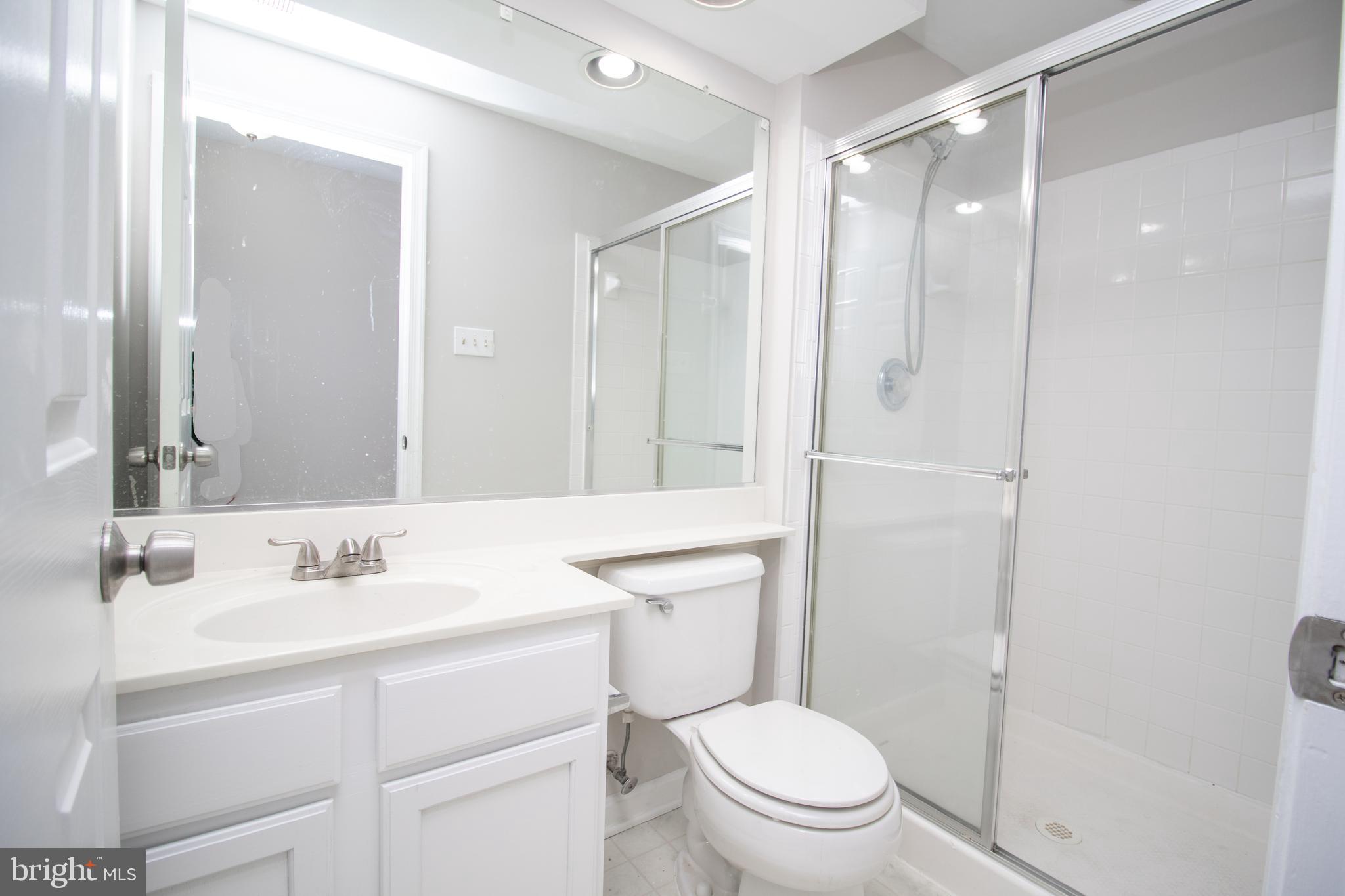 7708 Scatteree Road Severn, MD 21144 - Photo 33 of 41 a bathroom with a sink toilet vanity and shower